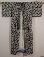 White plain-weave with overall black tie-dye design (black acid dye) in hitta kanoko.  The pattern consists of rectangular blocks of densely-packed tie-dye knots in rows of 5 x 12.  Lining is plain weave white silk with bokashi blue borders.