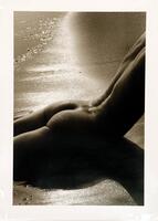 This photograph shows a nude figure lying prone, her torso extending out of frame, spine arching upwards, creating a shadow across the bottom of the composition. 
