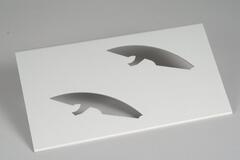 A white rectangular anodized aluminum plate with two laser-cut abstract designs.
