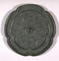 This mirror features designs of two birds, coupled with floral motifs, positioned symmetrically on the left and right sides. Eight-foiled barbed bronze mirror is general. This type is a modified form of that.<br />
<br />
This blue-green bronze mirror decorated with a double crane design is excellently cast. It is five-lobed, and the registers are also divided by five-lobe shaped ridge. The outer register is decorated with scroll design while the inner register is adorned with a pair of cranes, with wings spread and heads turned right, arranged on either side of the central suspension loop against the honeysuckle scroll background. This object may be compared to other crane-patterned mirrors excavated from the Geumcheondong site tomb in Cheongju, Chungcheongbuk-do Province.
<p>[Korean Collection, University of Michigan Museum of Art (2017), 240]</p>
