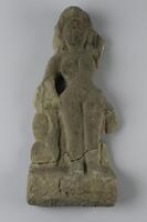 A nude female figure with decorative hair. The surface of the stone is worn down to obscure her facial features and her right lower arm and all of her left arm are broken off.&nbsp;