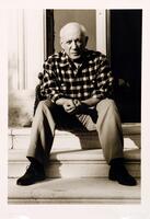 This portrait of a man shows him sitting on a set of steps, hands clasped between his knees. He wears a checkered shirt and long trousers.<br /><br />
EWP, 7/26/16: removed proper name, more appropriately included in Subject Matter