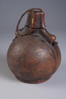 Globular container with small circular base and lid. Two holes are tunneled through the lid traveling vertically down the sides of the container. A thick piece of fiber is tied through the holes and knotted at each end. Triangular and diamond geometric designs are carved throughout the entire container.