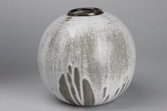 White glazed pot with a spherical shape. The underglaze is brown and creates a mottled pattern with the white overglaze.