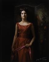 Image of a woman wearing a red dress, clutching a pink sash, leaning against a painted screen.&nbsp;