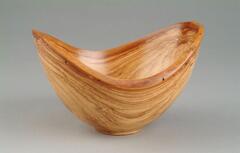 oval-shaped wood bowl with dipped lip; wood grain and spalt lines highly visible across surface