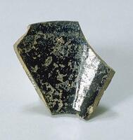 A six-sided fragment of a Jian Ware bowl&nbsp;with pitted black glaze.