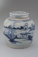 Blue-and-white covered jar with landscape design of a river, trees, mountain, houses and it has a lid with blue an white designs.