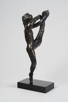 A bronze sculpture of a dancer. This dancer is shown stretching her leg up in the air.