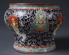 Bencharong ware spittoon made in a private kiln in Jingdezhen, China, for Thai market. Probably ordered from Thai royalty, under the reign of Rama II (r. 1809-1824). It is the porcelain ware enameled with multiple colors, in the style called “five colors” (“bencharong” refers to five colors in Sanskrit). It has a large mouth and bulbous shape, with design of minor Buddhist deities Thepanom and Norasingh, and Chinese fire patterns.<br />