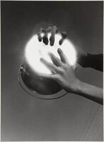 A black and white image of two hands holding an upside-down pail with light reflected from the bottom.
