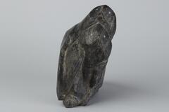 Carved gray stone sculpture of two birds with one behind the other.&nbsp;
