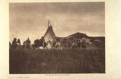 This is a photograph of a party of horses and riders. The subjects prepare to head to battle, with spears and regalia. Behind them is a tipi and prairie landscape.