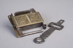 A square, brass lock with a carving on one side.  The key as geometric shapes instead of teeth.