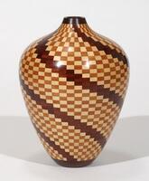 wood vase with geometric patterning that wraps across a top-bottom, left-right diagonal