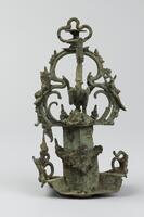 A delicately detailed sculpture featuring a circular base and sharply angled platform supporting a clover-shaped display with a cradle-like centerpiece. On top of this structure rests another smaller clover-shaped design attached separately by its ringed base.
