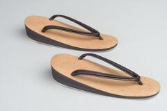 A pair of leather sandals with woven insoles and plastic soles. 
