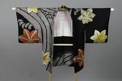 <p>Black rinzu haori with interwoven wave motifs with white shibori Oonami (large wave) motifs with dyed shibori light green, maroon, and yellow autumnal leaves with gold embroidery and miniature bamboo, plum blossom, dandelion, and chrysanthemum motifs with light pink and white peony lining.</p>
