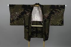 <p>black&nbsp; chirimen Eba-haori with interwoven gold shibori plum and maple motifs with a white and light pink inner lining with dyed daisies and plum blossoms with painted gold and silver-leaf eyes.</p>
