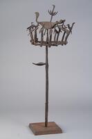 Iron staff with a circle of 14 small birds surrounding a large, central bird, which is topped by a smaller bird.&nbsp;