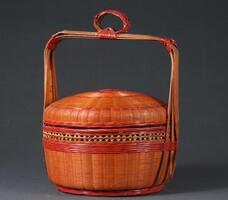 A round woven basket with a domed lid and a square handle with a loop in the middle of the top part.