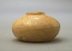 A small jar of squat proportions with short, vertical neck and a pale yellow, crackled glaze. This jar is very similar to 2002/2.23, also in UMMA collections.