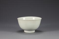 Deep porcelain bowl with wide foot, fine body, and colorless glaze.<br />
<br />
This high-quality white porcelain bowl is presumed to have been produced at official court kilns around Usan-ri, Gwangju-si, Gyeonggido. The well-levigated clay of finest quality was used for this bowl. Sagger was used to protect the bowl during firing to attain its pure white, immaculate surface. Entire foot of the bowl was glazed, and the foot was placed upon a fine white sand support to make the surface as clean as possible. The outer base is enscribed with Chinese character &ldquo;天&quot; (&ldquo;Cheon;&rdquo; sky, heaven)&rdquo; by scraping off the glaze. The characters &ldquo;大&rdquo; (&ldquo;Dae;&rdquo; big; great)&rdquo; and &ldquo;黃&rdquo; (&ldquo;Hwang;&rdquo; yellow) have been stippled after firing. Finely fused and sintered, this bowl exemplifies the essence of white porcelain made from offical court kilns, which is robust and white as a white jade.<br />
[Korean Collection, University of Michigan Museum of Art (20