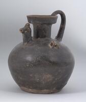 A stoneware globular bodied ewer with a narrow, flaring neck and dish-shaped mouth, a curved handle extending from the rim to the shoulder, a spout in the form of a chicken head, and two lug handles on the shoulder.  It is covered in a dark brown-black glaze. 