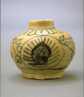 A small, stoneware jar of squat proportions, with a narrow, upright neck and a short, cylindricrical foot. The jar is decorated with loosely drawn floral patterns in cobalt blue underneath an overalll whitish glaze.