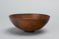A small bowl with reddish-brown coloration in a splash pattern. &nbsp;