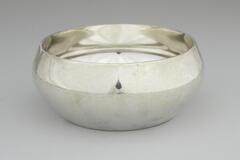 Silver bowl which is smaller at the base, widens in the center, and tapers at the top.&nbsp;
