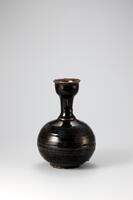 This bottle is black-glazed on its entire outer surface, including the inner rim. The glaze is well fused, forming a smooth, shiny surface. There are throwing marks on the entire body. The rim, which appears like a cup placed on top of the neck, is designed to stop liquid from spilling when poured. Bottle such as this one were widely used in everyday life.<br />
[Korean Collection, University of Michigan Museum of Art (2014) p.211]
