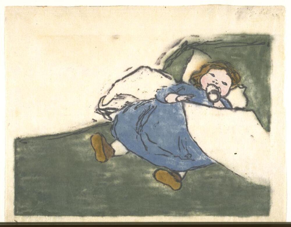 A small child dressed in blue lies on a bed with green and white covers. The child holds a small white bottle.