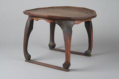 Wooden table with a dodecagon table top and rounded out legs.<br />
<br />
This dog-legged tray-table has its name derived from the shape of its curved legs which resemble those of dogs. The table top and its raised brim are made from the same single piece of thick board. Aprons between the legs, immediately under the table top, are not shaped in identical proportion, as they were initially made long and were shortened where it was needed. Bamboo pegs are driven into the table top to join it with the aprons, and the stretchers are nailed to the legs by nails driven in from the bottom.
<p>[Korean Collection, University of Michigan Museum of Art (2017) p. 258]</p>
