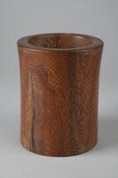 A wooden cylindrical brush holder.