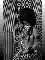 Black and white photograph of a woman sitting in front of vibrant geometric designed. Her dark hair hangs loose over her face and she wears numerous necklaces around her neck, including one that has a &#39;Gap&#39; price tag on it. She wears bangles and cuffs on her left arm.&nbsp;