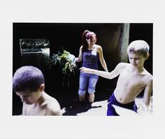 An image of a woman and two boys emerging from a concrete underpass. She is smiling and holding plants. Both boys are shirtless, the one on the right extending his right arm outward.