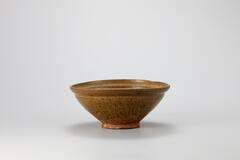 <p>The color and shape of this bowl are modeled after those of Chinese Yue ware. Bowls of this type have been excavated from the sedimentary layers of olive-brown-glazed celadon (nokcheongja) kiln site at Gyeongseo-dong, Incheon. There is a narrow shelf below the mouth rim, while the bowl has been coated with olive- brown-glaze. There are four refractory spur marks on the foot. Part of the body has been repaired after damage.<br />
[<em>Korean Collection, University of Michigan Museum of Art </em>(2014) p.100]</p>
Bowl has a barrow shelf below the mouth rim, and the bowl itself is coated with olve-brown glaze. There are four refractory spur marks on the foot and part of the body has been repaired after damage.