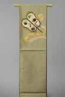 <p>pale brown-green silk fukuro (single-sided) obi with embroidered orange, yellow, and silver gunbai uchiwa (fan held by sumo wrestler referee) motif decorated with white, maroon, and pink wisteria, cherry blossoms, chrysanthemums, camellias,&nbsp; autumnal foliage, and orange ribbons with gold and silver cloud motifs.</p>
