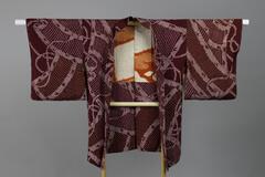 <p>Maroon shibori haori with dyed lavender kichou-mon (screen room divider) motifs with a white and orange shibori dyed lining with interwoven Oogi (fan) and mountain designs.</p>
