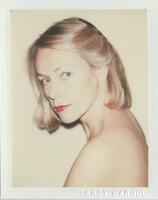 A bust-length portrait of a nude woman with her blonde hair pinned back on one side. She faces her body toward the left side of the frame, turning her head toward the camera.