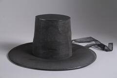 This type of hat (<em>gat</em>) was once the most commonly worn men&rsquo;s headgear by Korean aristocratic government officials and commoners. In the mid-Joseon period, they had tall crowns and wide brims. When Heungseon Daewongun (興宣大院君, 1820&ndash;1898), the father of King Gojong (高宗, r. 1863&ndash; 1907) seized power in the late Joseon period, he made the wearing of shorter crowns with narrower brims mandatory. This hat is in good condition despite some losses at the crown. The straps are made of black silk gauze.
<p>[Korean Collection, University of Michigan Museum of Art (2017) p. 282]</p>
