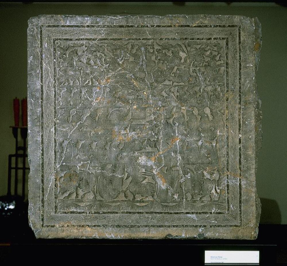 Limestone slab carved bas-relief with six registers. The lower register depicts a chariot procession above fish-inhabited waters. The central three registers depict figures carrying out funerary rites. The top register shows a winged creature with a human face flanked by two writhing dragons and other animals, including two rabbits and a nine-tailed fox.