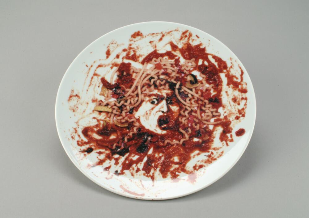 A photograph of a female head made of pasta and marinara sauce printed on a porcelain plate. On verso, the plate is numbered &quot;39;&quot; it is labeled part of &quot;The Peter Norton Family Christmas Project&quot; and dated 1999; the manufacturer is labeled &quot;Made in Bernardaud in Limoges, France;&quot; and, below, it reads &quot;Lead Free Dishwasher Safe.&quot;