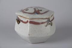 Lidded stoneware box with hexagonal base and sides.  Decorated with blue, copper, and lead underglaze painting under translucent glaze.