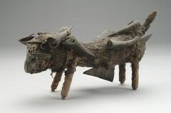 This zoomorphic Luba <em>nkisi mihake</em>, or “malevolent” power object, depicts a dog of a fierce and formidable character. Sculpted out of wood, the dog has been carefully covered in animal fur, creating a graphic mimetic effect. The dog’s tail stands nearly upright, signaling a commanding and attentive posture. Most striking, however, are the antelope horns, stuffed with medicinal substances, as well as the metal blades that have been affixed throughout the dog’s trunk and underbelly.