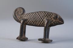 Small brass sculpture of a chameleon, tail is in a swirl.