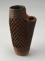 Terracotta pipe bowl in a cylindrical shape. The top and bottom edge are decorated with horizontal grooves, while the body of the bowl is covered with small round knobs. Another smaller, cylindrical projection—where the pipe stem would attach—is decorated in a crosshatch pattern. 