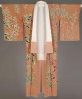 It is a pink silk crepe kimono with wax-resist patterns, hand-painted design and metallic threads embroidery. The kimono is in full length and has elongated sleeves. The fabric is dyed with pink, leaving the family crest under the collar and the floral design part white. The red scale pattern is added using wax-resist technique. Then the design of multiple kinds of plants is hand-painted with white, red, yellow, and pale and blue green colors. There are mix of fall and winter flowers and trees: nandin on the left sleeve, plum, chrysanthemums, thistles, amaranths, camellias and narcissus on the front and back, makino (Chloranthus glaber, with red berries) and more camellias on the right sleeve. Embroidery is added in various metallic threads around the contours of flowers and leaves.
