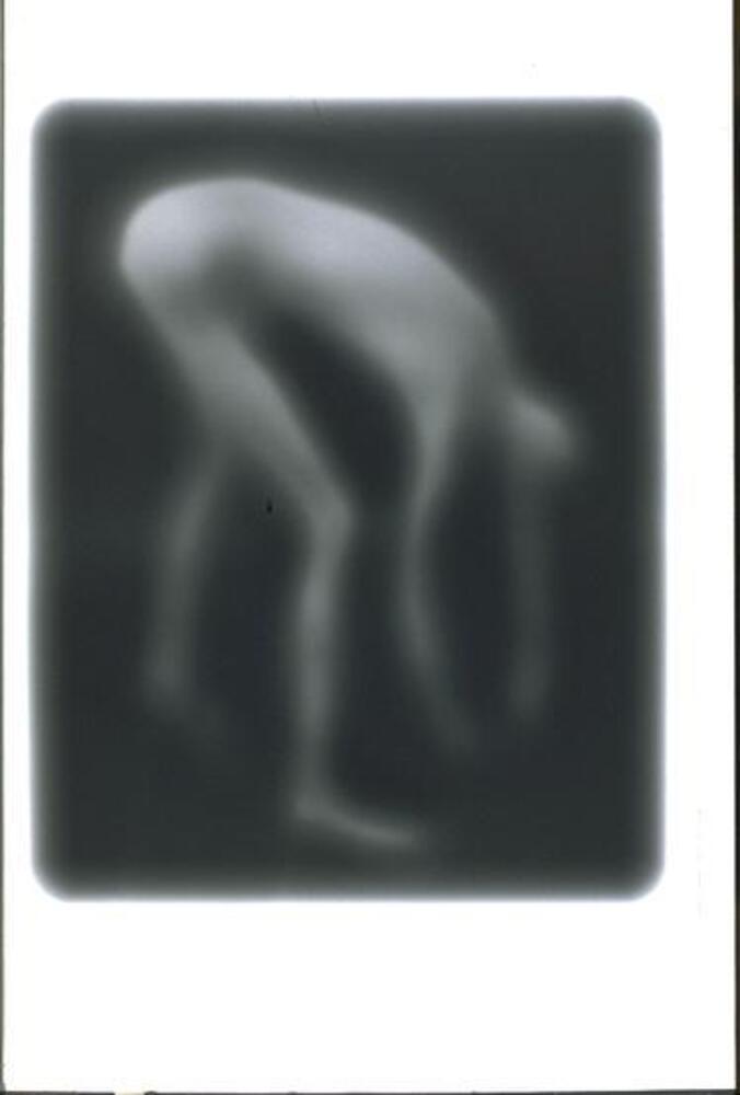 A blurred image of a nude figure bending forward, the arms nearly reaching the ground.